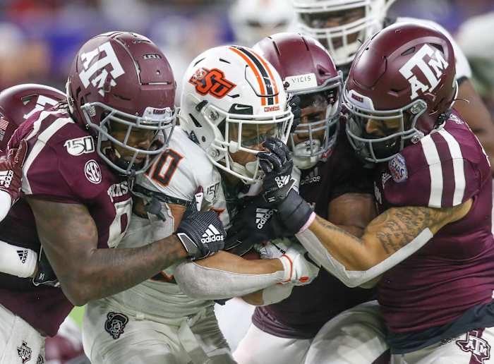 Oklahoma State Cowboys running back Chuba Hubbard (30) is face masked by Texas A&M Aggies defensive back Devin Morris (7) in the fourth quarter at NRG Stadium.